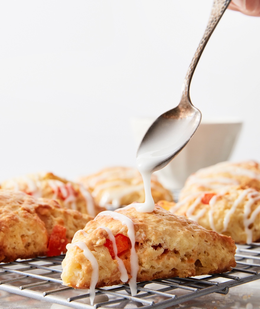 Drizzling scones with icing off a spoon