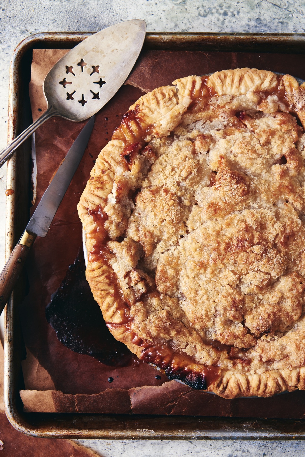 Apple pie with crumb topping set on a baking sheet, just out of the oven.